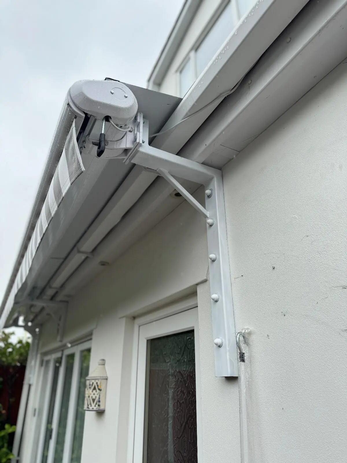 White and Grey Striped Residential Awning Installation - Stylish Sun Protection for Patio