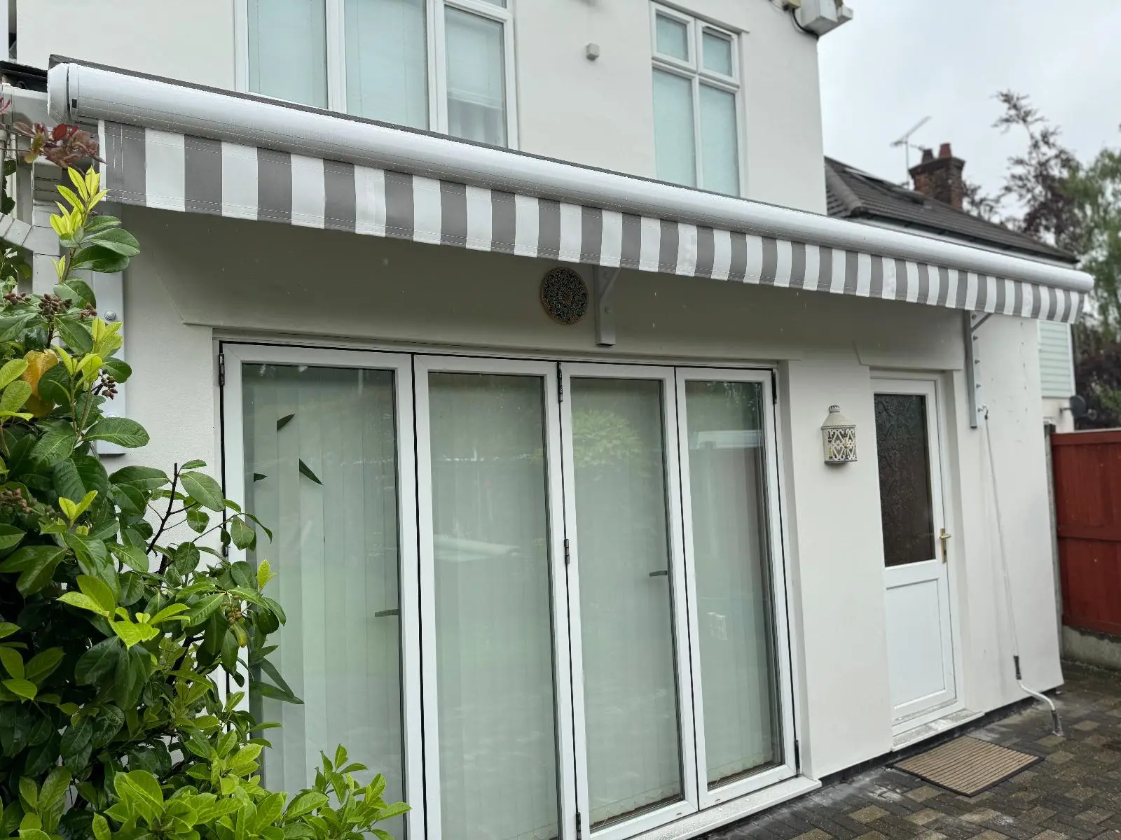 White and Grey Striped Residential Awning Installation - Stylish Sun Protection for Patio