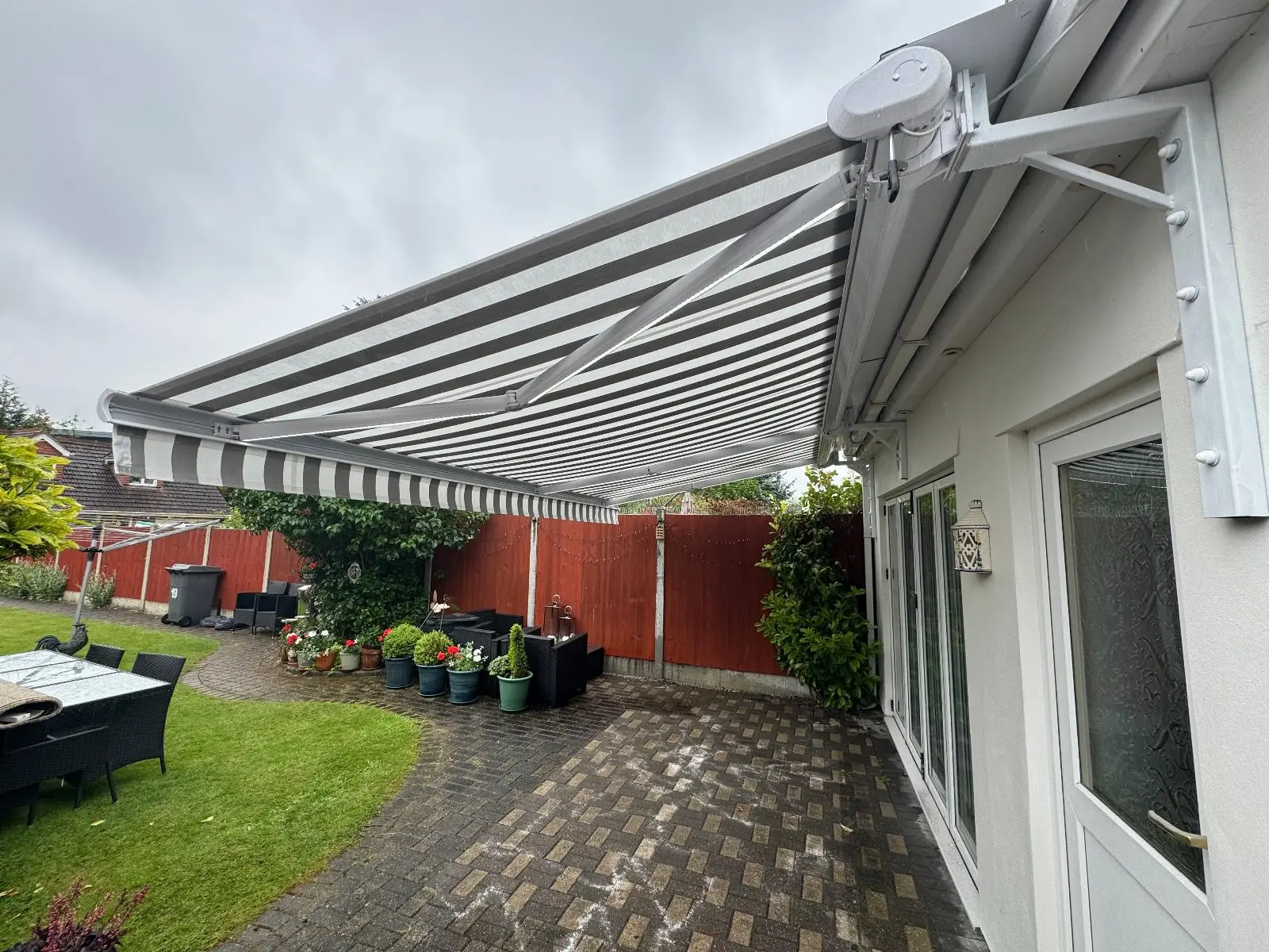 White and Grey Striped Residential Awning Installation - Stylish Sun Protection for Patio